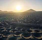 Aerial view of a woman walking among volcano holes formation at Timanfaya national park, Lanzarote Island, Canary Islands, Spain.