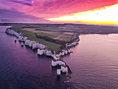 Luftaufnahme von Old Harry Rocks und dramatischen Klippen bei Sonnenuntergang über dem ruhigen Meer, Swanage, Dorset, Vereinigtes Königreich
