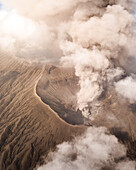 Aerial view of the majestic smoking volcano with a dramatic crater and ash, Sukapura, East Java, Indonesia.