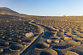 Aerial view of a woman walking among volcano holes formation at Timanfaya national park, Lanzarote Island, Canary Islands, Spain.
