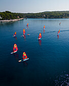 Luftaufnahme einer Windsurf-Regatta an der sonnigen dalmatinischen Küste, Kroatien.
