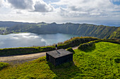 Azores, Portugal - 09 May 2021: Aerial view of a person standing on a concrete building facing Lagoa Azul on Ilha de Sao Miguel, Portugal.