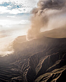 Aerial view of majestic volcanic crater with smoke and ash, Tosari, Pasuruan, East Java, Indonesia.