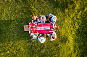Salgar, Colombia - 29 February 2020: Aerial view of a group of friends having a toast while eating on a hilltop with a beautiful landscape in background, Antioquia, Colombia.
