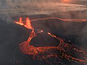 Aerial view of active volcanic eruption with flowing lava and smoke, Grindavik, Iceland.