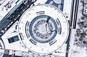Aerial view of a circular European Union building under the snow at wintertime near Parque du Cinquantenaire, Brussel, Belgium.