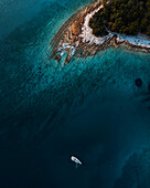 Aerial view of a sailboat along the coastline clear turquoise water and sandy coastline, Primorje-Gorski Kotar, Croatia.