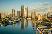Aerial view of Outdoor Stage theatre along the Nerang river with Gold Coast cityscape in background at sunset, Queensland, Australia.