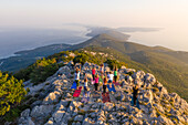 Luftaufnahme einer Gruppe, die auf dem Gipfel eines Berges Yoga praktiziert, Veli Lošinj, Kroatien.