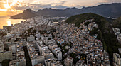 Drohnenansicht der Favela von Cantagalo mit der Stadt Rio de Janeiro im Hintergrund im Sonnenuntergang, Rio de Janeiro, Brasilien