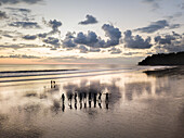 Aerial view of silhouettes of people dancing on beach at sunset, Costa Rica.
