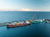 Luftaufnahme eines Frachtschiffs und eines Krans im Hafen, Ponta Delgada, Azoren, Portugal.