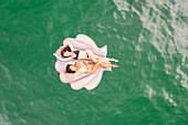 Aerial view of attractive girls with an inflatable at Gordons Bay, Sydney. Australia.