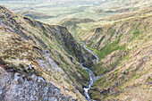 Aerial view of a river streaming along the valley near Captains Bay on Unalaska island, Alaska, United States.
