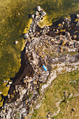 Aerial view of blue boat in abstract natural surrounding on the coastline of island of Vormsi in Estonia