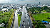 Aerial view of mile one flyover with busy traffic and modern buildings amidst greenery, Port Harcourt, Nigeria.