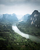 Aerial view of majestic karst mountains and a winding river in a serene valley, Guilin, China.