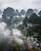 Aerial view of beautiful karst mountains and serene valley shrouded in fog, Guilin, China.