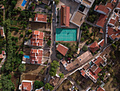 Aerial view of a football training pitch in a suburban setting, Alte, Portugal. View of the red tiled roofs, traditional architecture of Portugal