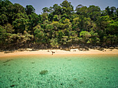 Luftaufnahme einer Frau allein am paradiesischen Strand der Insel Koh Rok Yai in Thailand.