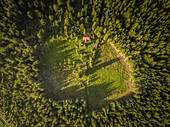 Aerial view of a farmland property isolated in the middle of the forest in Estonia.