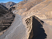 Aerial view of barren, rocky terrain with dry riverbed in remote location, Chhoser, Gandaki, Nepal.