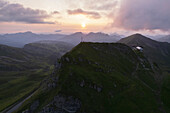 Luftaufnahme der nebligen Sommerberge mit Skilift und Antenne bei Sonnenuntergang, Val d'Illiez, Schweiz.
