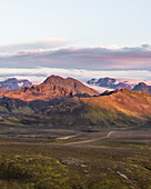 Aerial view of a beautiful mountain landscape with Torfajokull mountain in background at sunset in the highlands near Hella, Southern Region, Iceland.