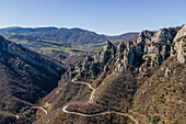 Luftaufnahme einer Straße entlang des Bergkamms in den Lukanischen Dolomiten (Dolomiti Lucane), einem Gebirgszug in der Nähe von Pietrapertosa, Potenza, Basilicata, Italien