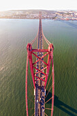 Panoramablick aus der Vogelperspektive auf die Autobahn am 25. April, Brücke über den Tejo mit der Innenstadt von Lissabon im Hintergrund, Lissabon, Portugal.