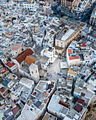 Aerial view of Polignano a Mare old town with main square full of tourist near the beach facing the Mediterranean sea, Puglia, Italy.
