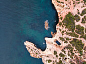 Luftaufnahme von oben auf die wilde Küste in der Nähe von Praia da Marinha mit kleinen paradiesischen Stränden bei Sonnenaufgang, Lagoa, Algarve-Region, Portugal