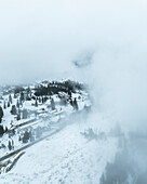 Aerial view of Carezza Lake and the snowy Dolomites in Welschnofen, South Tyrol, Italy.