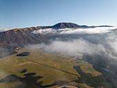 Luftaufnahme des Laceno-Sees (Lago Laceno), eines Stausees auf einem hoch gelegenen Berg mit niedrigen Wolken und Nebel in Bagnoli Irpino, Avellino, Irpinia, Kampanien, Italien