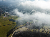 Luftaufnahme des Laceno-Sees (Lago Laceno), eines Stausees auf einem hoch gelegenen Berg mit niedrigen Wolken und Nebel in Bagnoli Irpino, Avellino, Irpinia, Kampanien, Italien