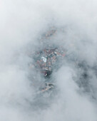 Luftaufnahme von Trentinara, einer kleinen Stadt auf einem Berggipfel mit niedrigen Wolken und dichtem Nebel Salerno, Kampanien, Italien.