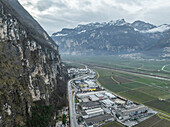 Luftaufnahme von Salorno mit Weinberg, Industrie und Gebirge, Südtirol, Italien.