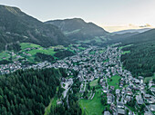 Luftaufnahme von St. Ulrich, einem kleinen Dorf in den Dolomiten, bei Sonnenuntergang, Trentino, Südtirol in Norditalien