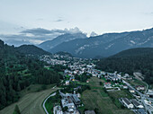 Luftaufnahme von Valle di Cadore, einer kleinen Stadt in einem Tal zwischen den Dolomiten bei Sonnenuntergang, Venetien, Belluno, Italien.