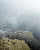 Luftaufnahme des Laceno-Sees (Lago Laceno), eines Stausees auf einem hoch gelegenen Berg mit niedrigen Wolken und Nebel in Bagnoli Irpino, Avellino, Irpinia, Kampanien, Italien