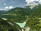 Aerial view of Valle di Cadore Lake, a mountain lake on the Dolomites with Mount Antelao in background in Valle di Cadore, Veneto, Belluno, Italy.