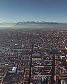 Aerial view of Turin downtown in evening haze at sunset with the Alps mountain range in background, Turin, Piedmont, Italy.