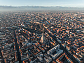 Aerial view of the Mole Antonelliana tower, a landmark building in Turin downtown at sunset with the Alps mountains range in background, Turin, Piedmont, Italy.
