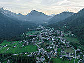 Luftaufnahme von Valle di Cadore, einer kleinen Stadt in einem Tal zwischen den Dolomiten bei Sonnenuntergang, Venetien, Belluno, Italien.