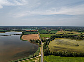 Luftaufnahme des ruhigen Parc des Oiseaux mit üppigen Feldern, einem ruhigen See und üppigem Grün, Marlieux, Frankreich.
