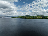 Aerial view of serene Loch Lomond surrounded by lush hills and tranquil clouds, Trossachs National Park, Scotland, United Kingdom.