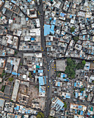 Aerial view of densely populated urban landscape with blue roofs and yellow taxis amidst traditional architecture, Jodhpur, India.