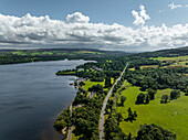 Aerial view of serene Loch Lomond surrounded by lush greenery and tranquil clouds, Trossachs National Park, United Kingdom.