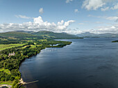 Aerial view of serene Loch Lomond surrounded by majestic mountains and lush greenery, Alexandria, United Kingdom.