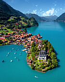 Aerial view of Iseltwald with is Castle Seeburg, boats, houses and lake in Canton of Bern, Switzerland